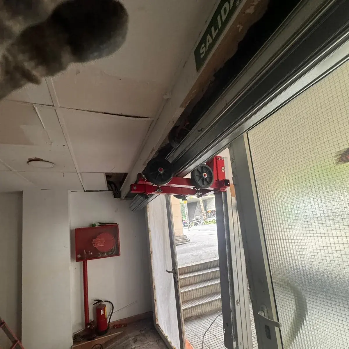 Instalación de la guía superior de una puerta de garaje en un local de Barcelona