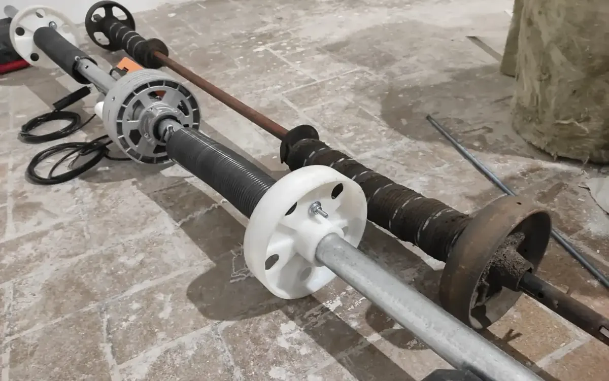 Motor y eje de una puerta de garaje de comunidad durante una revisión de mantenimiento